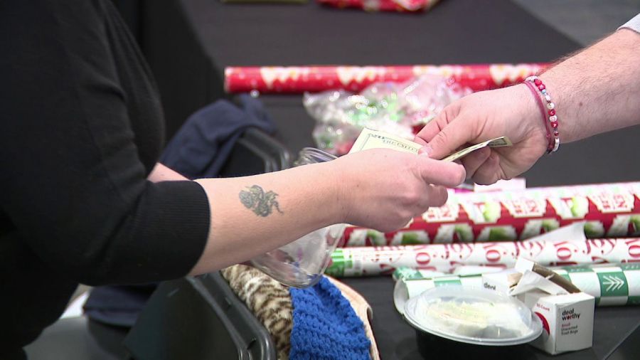 Groups man gift-wrapping booth for good causes