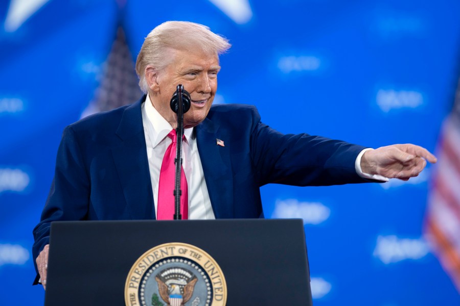 Trump revels in mass federal firings and jeers at Biden before adoring conservative crowd